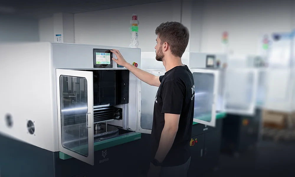 A man in a black t-shirt operates a REFOX AP25 grinding and polishing machine  in a modern industrial lab setting.