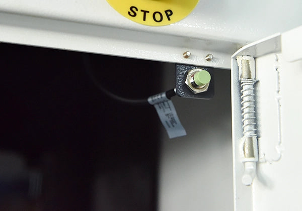 Close-up of a refox polishing machine with a 'STOP' label on a white background