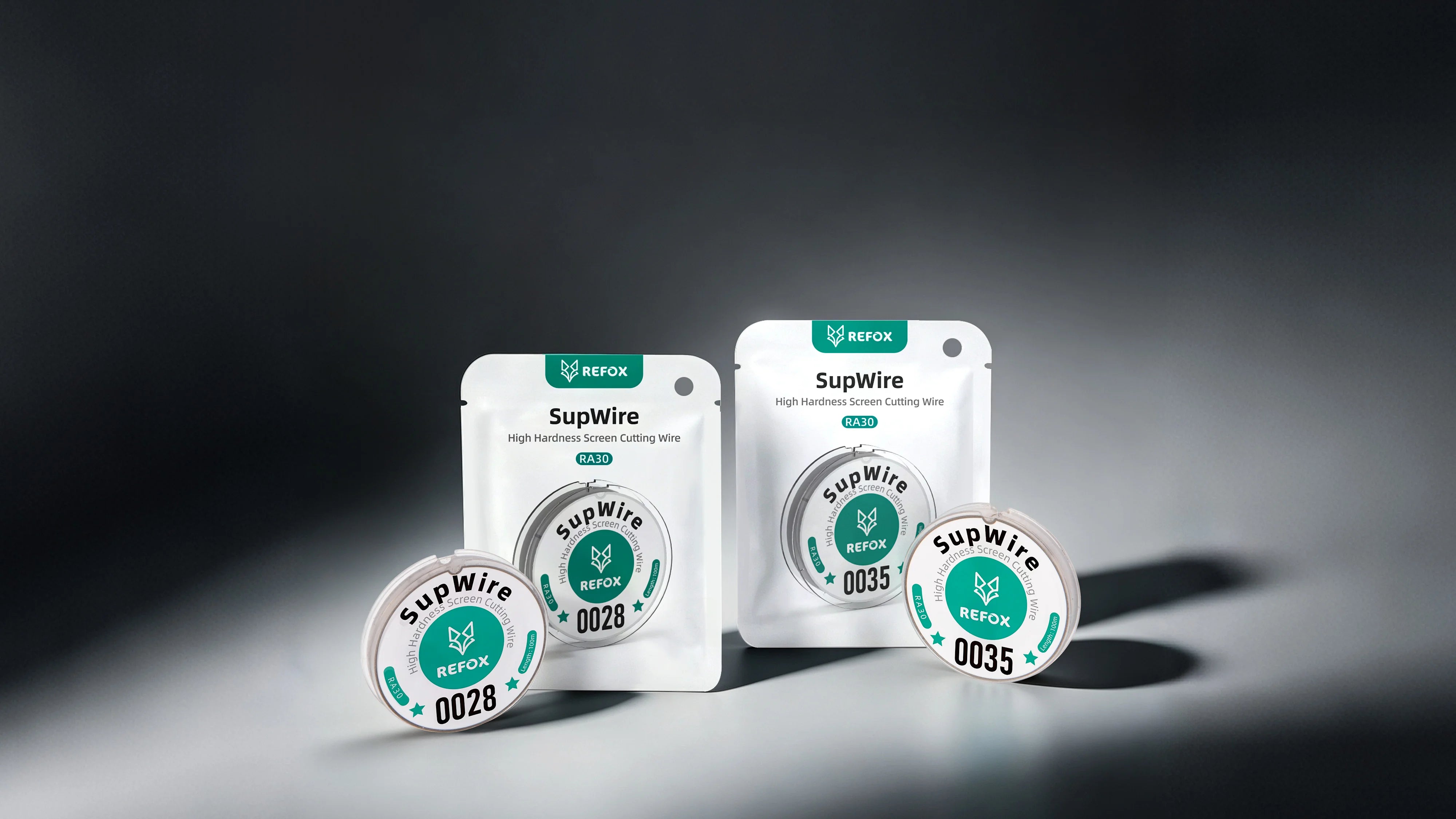 Two small white SupWire product pouches and two round metal canisters with teal and white labels, arranged on a dark gray studio background. The visible branding reads SupWire and REFOX.