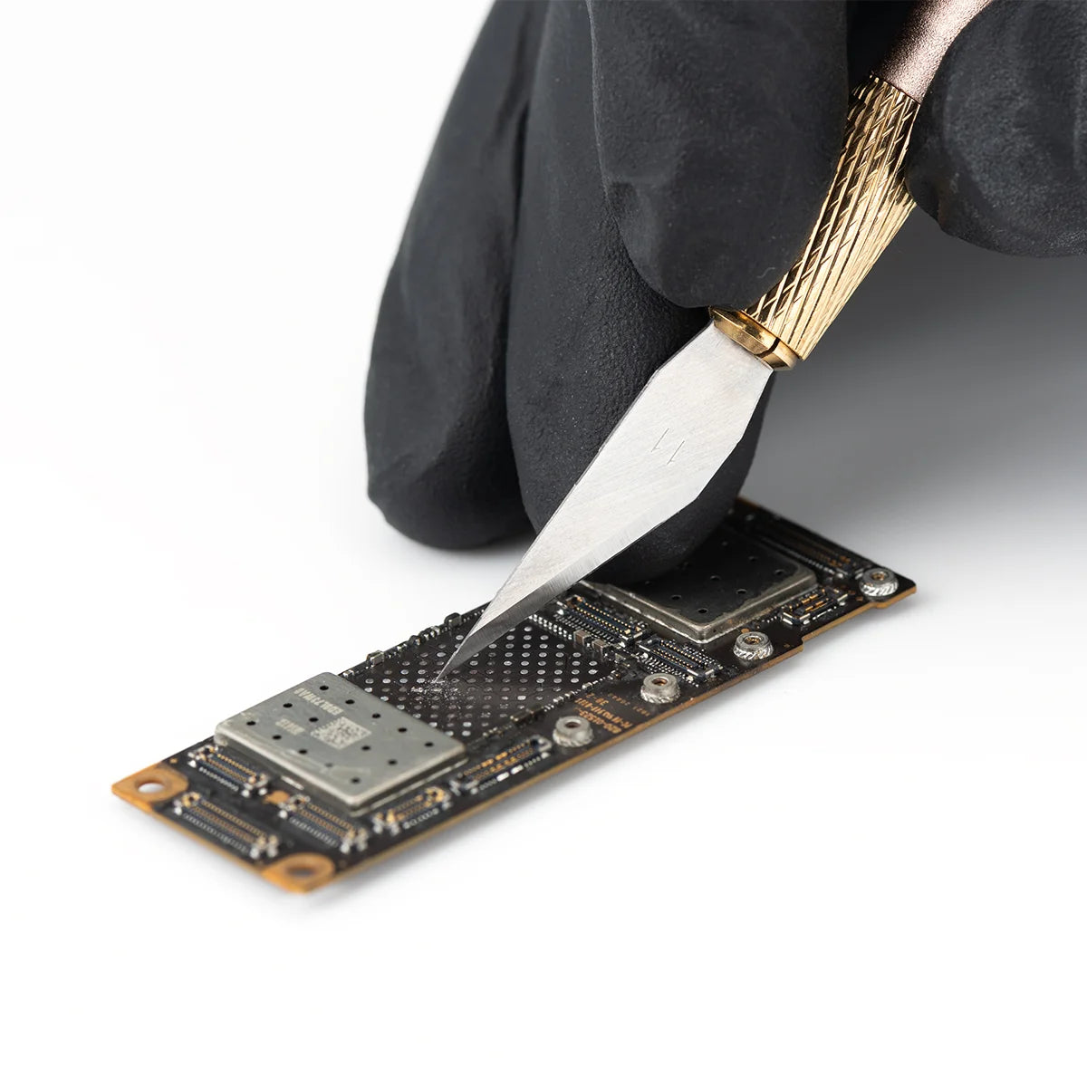 Person using a refox knife to work on fixing a phone chip a white background