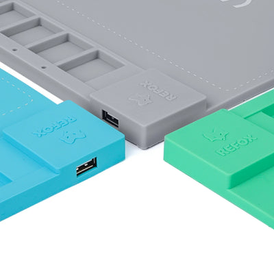 Drei Refox Silikon-Heizkissen in Grau, Blau und Grün mit USB-Anschlüssen auf weißem Hintergrund.