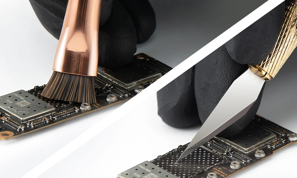 Close-up of a hand using a brush and blade on electronic components.