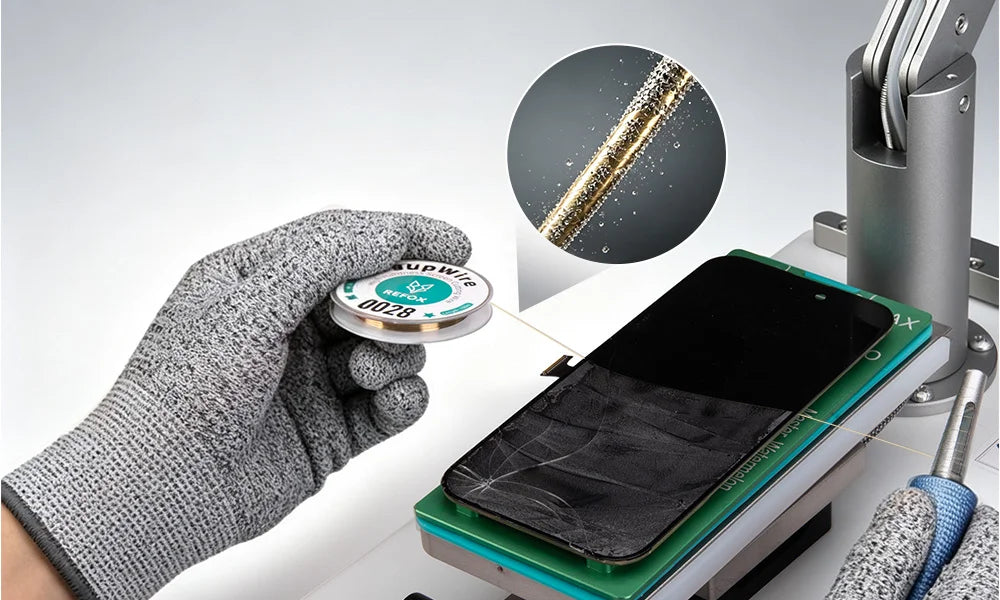 A gloved hand holds a small spool of clear screen repair cutting wire over a smartphone lying on a green repair mat, with a circular inset showing the adhesive being applied to a cracked glass surface.